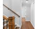 Interior staircase features wooden stairs and handrail with neutral walls at 515 Pearl St, Cumming, GA 30040