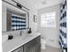 Updated bathroom with dark vanity, quartz countertop, and blue striped shower curtain at 2233 Troutdale Dr, Decatur, GA 30032