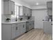 Modern kitchen with gray shaker cabinets, white quartz countertops, and herringbone backsplash at 2233 Troutdale Dr, Decatur, GA 30032