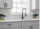 Modern kitchen sink with black faucet and herringbone backsplash at 2233 Troutdale Dr, Decatur, GA 30032