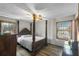 Bedroom with a four-poster bed, wood-look flooring, and natural light from two windows at 1330 Hillcrest Dr, Sugar Hill, GA 30518
