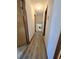 Well-lit hallway with wood-look flooring, leading to rooms, and overhead lighting at 1330 Hillcrest Dr, Sugar Hill, GA 30518