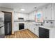 Clean kitchen featuring white cabinets, black appliances, modern countertops, and wood floors at 1330 Hillcrest Dr, Sugar Hill, GA 30518