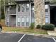 Gray condo building with stone accents, private balcony, and parking at 4083 Woodridge Way, Tucker, GA 30084