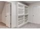 Finished basement featuring built-in shelving, a door to unfinished storage, and neutral carpet at 1630 Bettis Tribble Gap Rd, Cumming, GA 30040