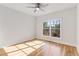 Sunlit bedroom features hardwood floors, a ceiling fan, and a large window at 1630 Bettis Tribble Gap Rd, Cumming, GA 30040
