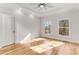 Sunlit bedroom with hardwood floors, ceiling fan and decorative tray ceiling and bright, large windows at 1630 Bettis Tribble Gap Rd, Cumming, GA 30040