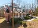 Exterior view of brick home with covered porch, dormer windows and professional landscaping at 1630 Bettis Tribble Gap Rd, Cumming, GA 30040