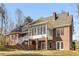 Exterior of two-story brick home with sunroom, covered porch, and backyard at 1630 Bettis Tribble Gap Rd, Cumming, GA 30040