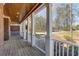 Inviting front porch featuring a stained wood ceiling and elegant white railings, showcasing outdoor living at 1630 Bettis Tribble Gap Rd, Cumming, GA 30040