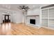 Open-concept living space featuring a brick fireplace, hardwood floors, and a decorative front door at 1630 Bettis Tribble Gap Rd, Cumming, GA 30040