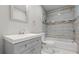 Modern bathroom featuring gray tiled walls, a shower and tub combo, plus a vanity with bright white sink at 2183 Pansy Nw St, Atlanta, GA 30314