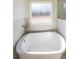Relaxing bathtub with modern fixtures and marble tile accents at 5470 Crow Dr, Cumming, GA 30041