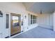Covered front porch with wood front door and gray shutters at 5470 Crow Dr, Cumming, GA 30041