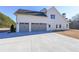 Three-car garage with gray doors and a large concrete driveway at 5470 Crow Dr, Cumming, GA 30041