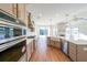 Open concept kitchen with island, stainless steel appliances, and hardwood floors at 5470 Crow Dr, Cumming, GA 30041