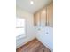 Bright laundry room with wood flooring and ample cabinets at 5470 Crow Dr, Cumming, GA 30041