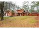 Exterior showcasing the home's well-maintained lawn, stone chimney, attached garage, and a separate storage shed at 4800 Silverberry Nw Ln, Acworth, GA 30102