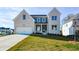 Two-story house with white brick and gray siding, featuring a front porch and attached two-car garage at 5435 Crestline View Rd, Cumming, GA 30028