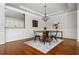 Elegant dining room featuring hardwood floors, wainscoting, contemporary light fixture, and a view into the kitchen at 570 Parkside Village Nw Way # 12, Marietta, GA 30060