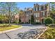 Townhome exterior with a manicured lawn, mature trees, and black shutters at 570 Parkside Village Nw Way # 12, Marietta, GA 30060