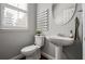 Well-lit half bathroom featuring a pedestal sink, and a decorative mirror at 570 Parkside Village Nw Way # 12, Marietta, GA 30060