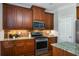 Modern kitchen featuring stainless steel appliances, granite countertops, wood cabinets, and hardwood floors at 570 Parkside Village Nw Way # 12, Marietta, GA 30060