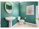 Clean bathroom with pedestal sink and teal walls at 7825 Brands Hatch Blvd, Cumming, GA 30040