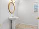 Small powder room with pedestal sink and tile floor at 7825 Brands Hatch Blvd, Cumming, GA 30040