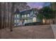 Exterior view of a charming two-story green house at dusk at 7825 Brands Hatch Blvd, Cumming, GA 30040