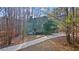 Two-story house with turret and long driveway, nestled in the woods at 7825 Brands Hatch Blvd, Cumming, GA 30040