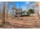 Green two-story house with a turret and wrap-around porch, nestled among trees at 7825 Brands Hatch Blvd, Cumming, GA 30040