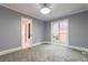 Well-lit bedroom with gray walls, carpet, and access to a bathroom at 9635 Haverhill Ln, Johns Creek, GA 30022