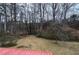 An expansive backyard with dormant grass and many mature trees in a densely wooded area at 4225 Parkridge Dr, Powder Springs, GA 30127