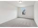 The standard bedroom features neutral carpeting and a standard window with trees outside at 7289 Eton Ln, Locust Grove, GA 30248