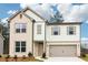 Charming two-story home with a brick and siding exterior, complemented by a well-manicured lawn and two-car garage at 7289 Eton Ln, Locust Grove, GA 30248
