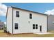 View of the rear exterior of a new construction two-story home with a white siding and adjacent concrete patio at 7289 Eton Ln, Locust Grove, GA 30248