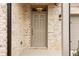 Elegant front door with a classic design, complemented by brick accents and a modern light fixture, creating a welcoming entrance at 7289 Eton Ln, Locust Grove, GA 30248