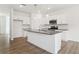 Modern kitchen with stainless steel appliances, a large island, and white cabinets offering style and functionality at 7289 Eton Ln, Locust Grove, GA 30248