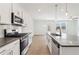 Well-lit kitchen with stainless steel appliances, granite countertops, and white cabinets creating a sleek cooking space at 7289 Eton Ln, Locust Grove, GA 30248