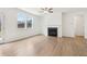 Cozy living room featuring hardwood floors, a fireplace, and large windows, creating a warm and inviting atmosphere at 7289 Eton Ln, Locust Grove, GA 30248