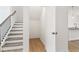 Staircase with wood handrail and white risers, plus a storage area at 7289 Eton Ln, Locust Grove, GA 30248