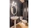 Small bathroom with pedestal sink, toilet and black and white striped walls at 3928 Princeton Lakes Sw Way, Atlanta, GA 30331