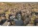 Expansive aerial view of homes nestled in a lush, wooded landscape with a long driveways and cul-de-sac at 9475 Dunmoore Dr, Cumming, GA 30028