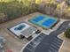 Aerial view of community amenities, featuring a pool, tennis courts, and parking with accessible spots at 9475 Dunmoore Dr, Cumming, GA 30028