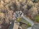 Stunning aerial view of a house with a long driveway surrounded by beautiful trees at 9475 Dunmoore Dr, Cumming, GA 30028