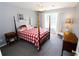 Bedroom with a full-size bed, red and white bedding, and a reading chair at 3854 Heritage Crest Pkwy, Buford, GA 30519