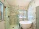 Bathroom featuring a glass shower, freestanding tub, tile flooring, and window at 5619 Mayfair Crossing Dr, Lithonia, GA 30038