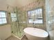 Bathroom featuring a glass shower, freestanding tub, tile flooring, and window at 5619 Mayfair Crossing Dr, Lithonia, GA 30038