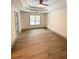 Spacious bedroom with wood-look flooring, ceiling fan, and large window at 5619 Mayfair Crossing Dr, Lithonia, GA 30038